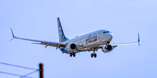 A sleek airplane glides effortlessly through the clear blue sky, its wings poised like a bird in...