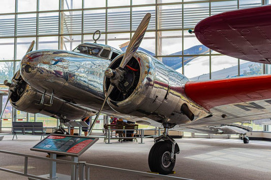 A gleaming vintage aircraft rests gracefully within the museum's sun-drenched atrium, its polished...
