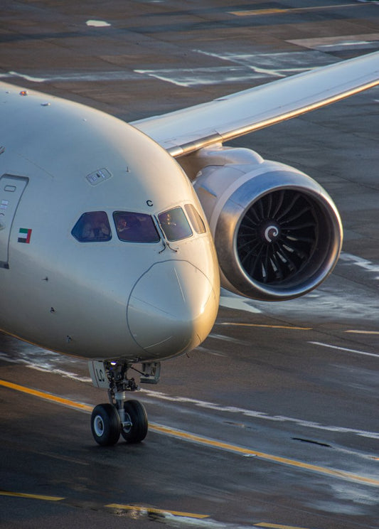 In the golden hues of evening light, an aircraft readies for takeoff, its sleek form glistening...