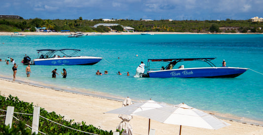 In a captivating scene of leisure, vibrant blue boats named 'Up To You' and 'Rum Rush' anchor in...