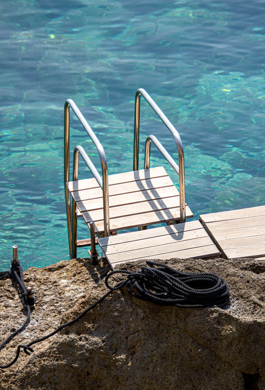 A gleaming metal ladder descends into the crystalline waters, inviting the viewer to dive into the...